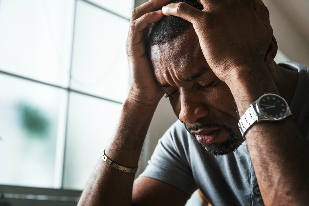 Man holding his head while struggling with feelings of loneliness